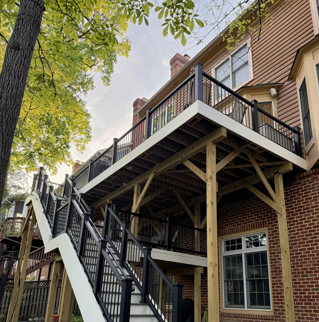 New two-level deck with black railings and a white switchback stair
